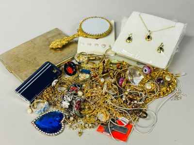 a pile of gold jewelry on a table next to a mirror
