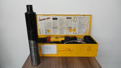 une boîte jaune posée sur une table et contenant quelques outils