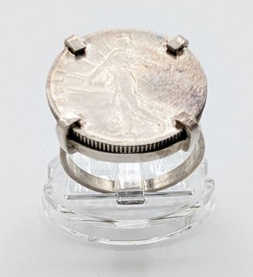une pièce d'argent posée sur un support en verre transparent