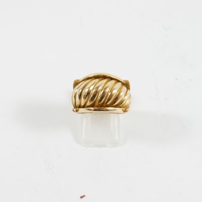 gros plan d'une bague en or sur une surface blanche