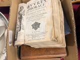 an open book in a box on top of a pile of books