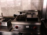 a picture of a commercial kitchen with two fryers on the stove