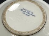 a white plate with blue writing on it sitting on a table