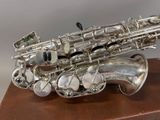 a silver saxophone sitting on top of a wooden table