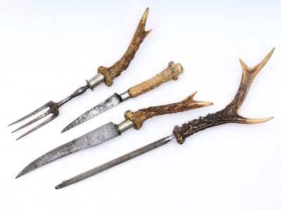 quatre types différents de couteaux ornés de bois de cerf, posés sur un fond blanc
