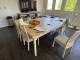 a wooden table with chairs and a television in the room