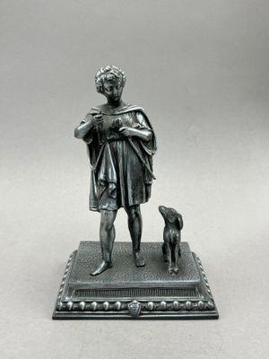 a silver statue of a man with a dog on a base