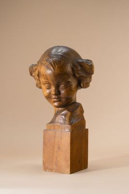 bronze bust of a young girl on a wooden base