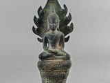une image représentant une statue de Bouddha assis au sommet d'un vase