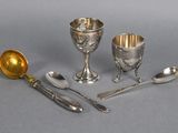 three silver plated goblets, spoons and spoon rest on a gray surface