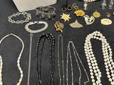 several necklaces, bracelets, and other jewelry are displayed on a table