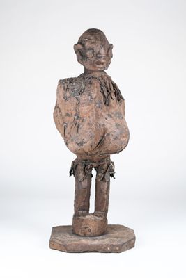 une vieille statue en bois d'un homme avec un chapeau sur la tête