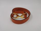 bracelet en cuir orné de lunettes plaquées or sur fond blanc