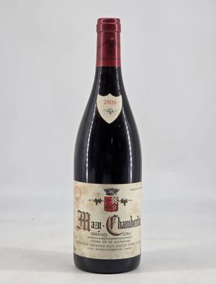a bottle of red wine sitting on top of a white table