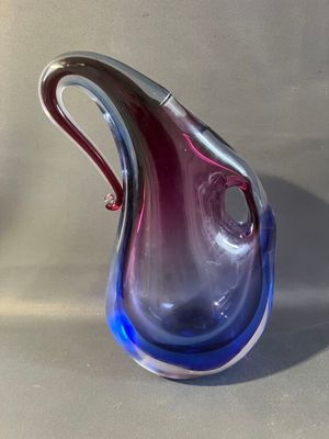 un vase en verre bleu et violet posé sur une table