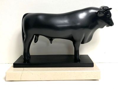 a statue of a black cow standing on a marble base