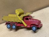 un petit camion rouge avec une benne jaune à l'arrière