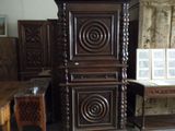 a tall wooden cabinet in the middle of a room