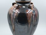 a black and brown vase with a light on it