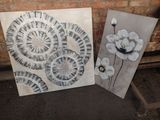 two paintings of white flowers on a brick wall next to a brick wall