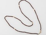 a close up of a long brown rope with a gold clasp