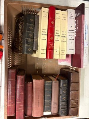 many old books in a box on a shelf