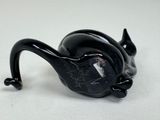 a black cat figurine sitting on a white surface
