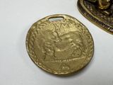 two pieces of gold coins sitting on top of a white table