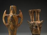 two brown vases sitting next to each other on a gray surface
