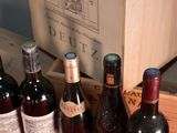 several bottles of wine are lined up in a wooden box