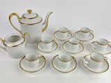 a white and gold tea set with cups and saucers
