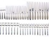 a lot of forks and spoons on a white table