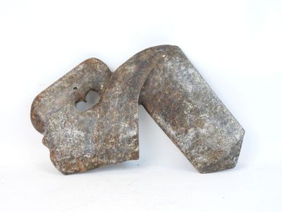 two pieces of old metal are sitting on a white surface