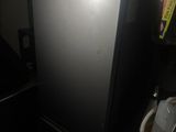 a refrigerator that is sitting in the corner of a room