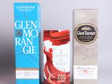 two boxes of chocolate and a bottle of wine on a table