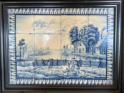 a blue and white tile with a picture of a man and a woman in a boat