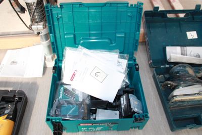 a green tool box filled with assorted items on a table