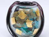 a glass vase with a gold and blue design on it