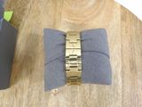 a gold bracelet on a gray pillow on a wooden table