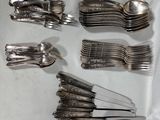beaucoup de cuillères et de fourchettes en argent sur une table