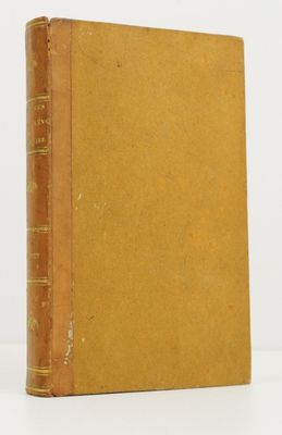 an old book sitting on top of a table next to a white wall