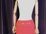 un mannequin vêtu d'une jupe rouge, posé sur un pied de mannequin