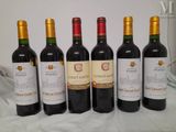 four bottles of wine are lined up on a table