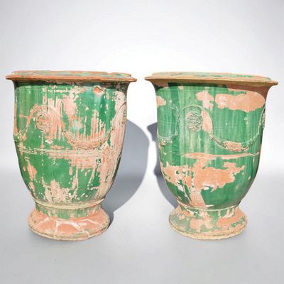deux vases verts posés l'un à côté de l'autre sur une table