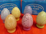 four egg shaped salt and pepper shakers are sitting on an orange cloth