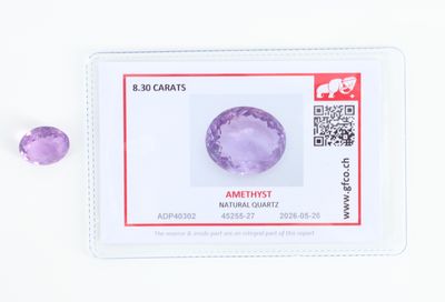 un gros plan sur des pierres précieuses violettes posées sur une surface blanche