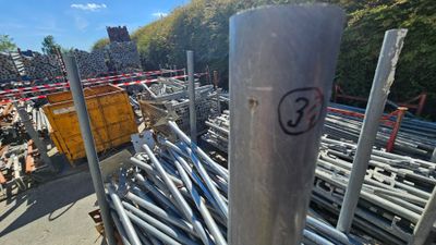 un gros tas de tuyaux en acier posé sur le bord de la route