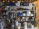 de nombreux seaux de peinture sur les étagères du garage