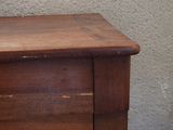 a wooden dresser with a clock on top of it
