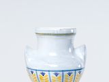 un vase blanc orné d'un motif bleu et jaune